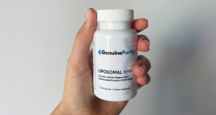 Hand holding GenuinePurity™ NMN product bottle on a white wall background