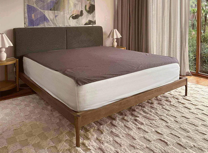 Premium Grounding & Earthing bed sheet lifestyle image with carpet, drapes, and two bedside lamps