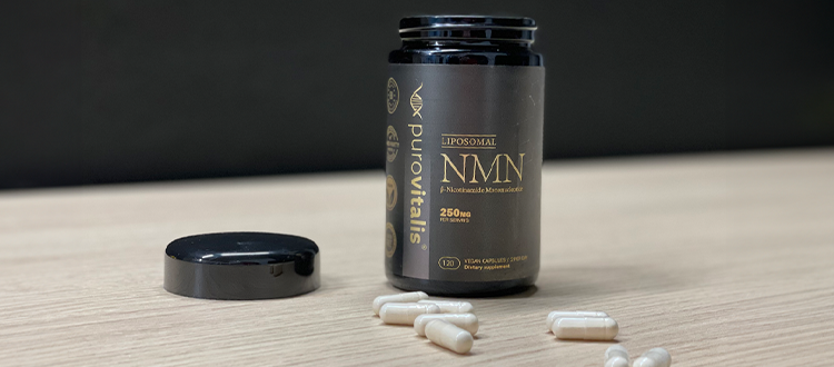 Open Purovitalis Liposomal NMN bottle standing on a wooden table, with pills scattered beside it