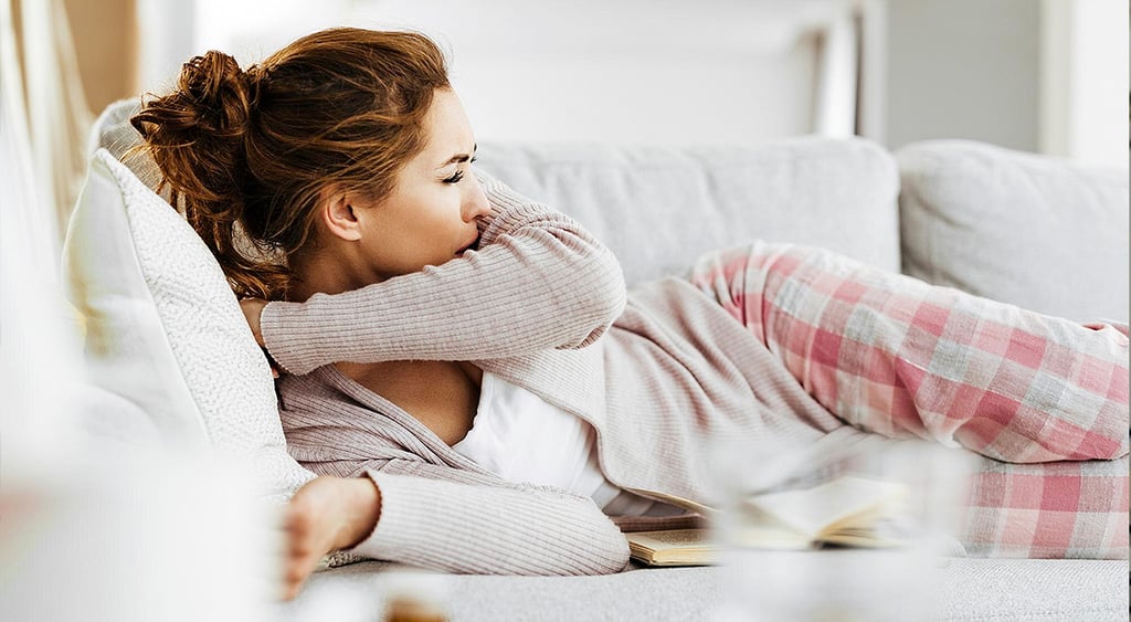 Woman in bed coughing
