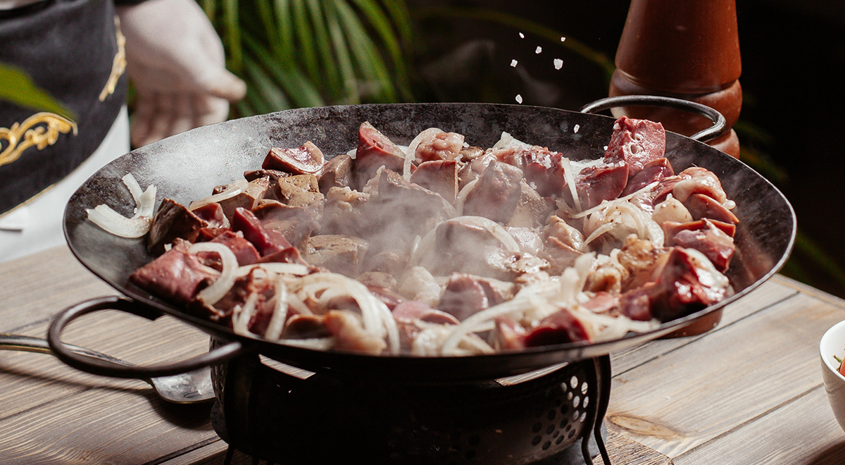 meats frying in a chinese wok pan