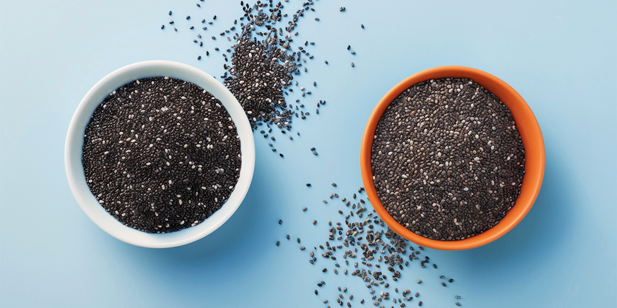Spilled basil and chia seeds in white and orange bowls on a blue table