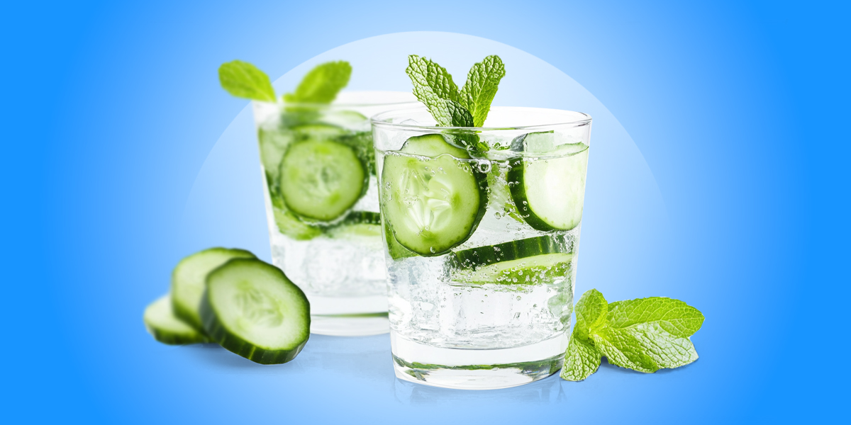 Sliced pickles in a glass cup of water blue background