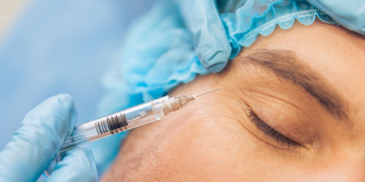 Portrait of a person receiving a face injection, lying down with eyes closed