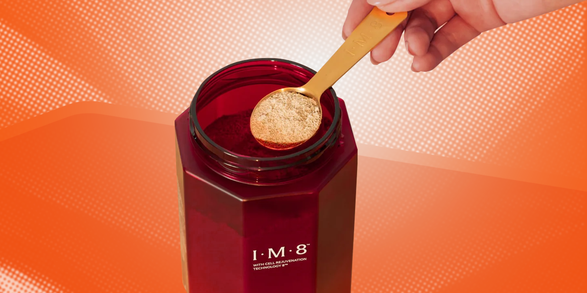 Spoon pulled from a bottle of All-in-One Supplement by David Beckham on an orange background