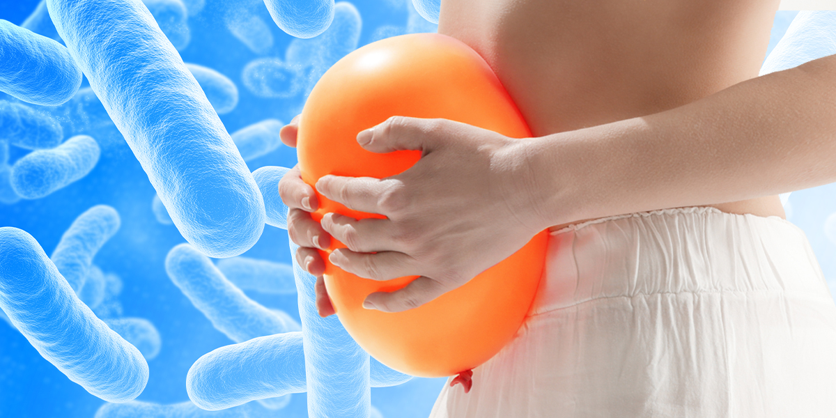 Persons belly hugging orange balloon with blue probiotic background