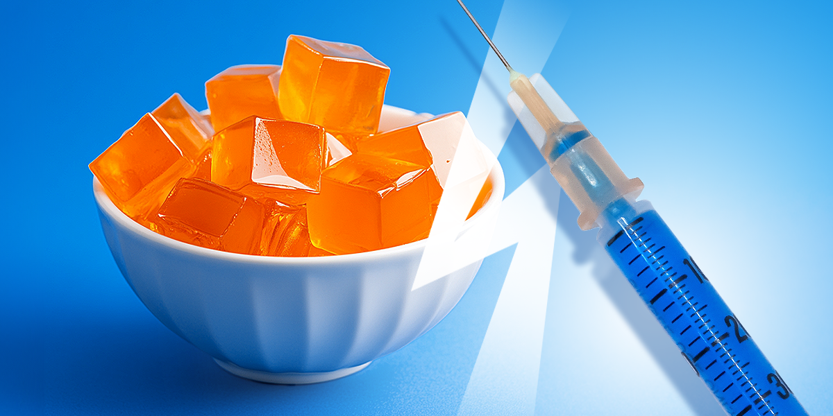 A small bowl of gelatin cubes and a syringe on the blue bakcground