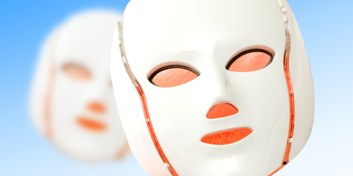 Two red light therapy masks set against a blue background