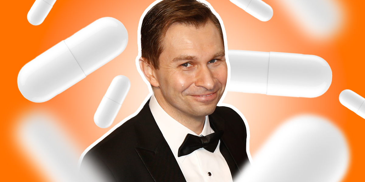 David Sinclair in a suit with orange background consisting of pills