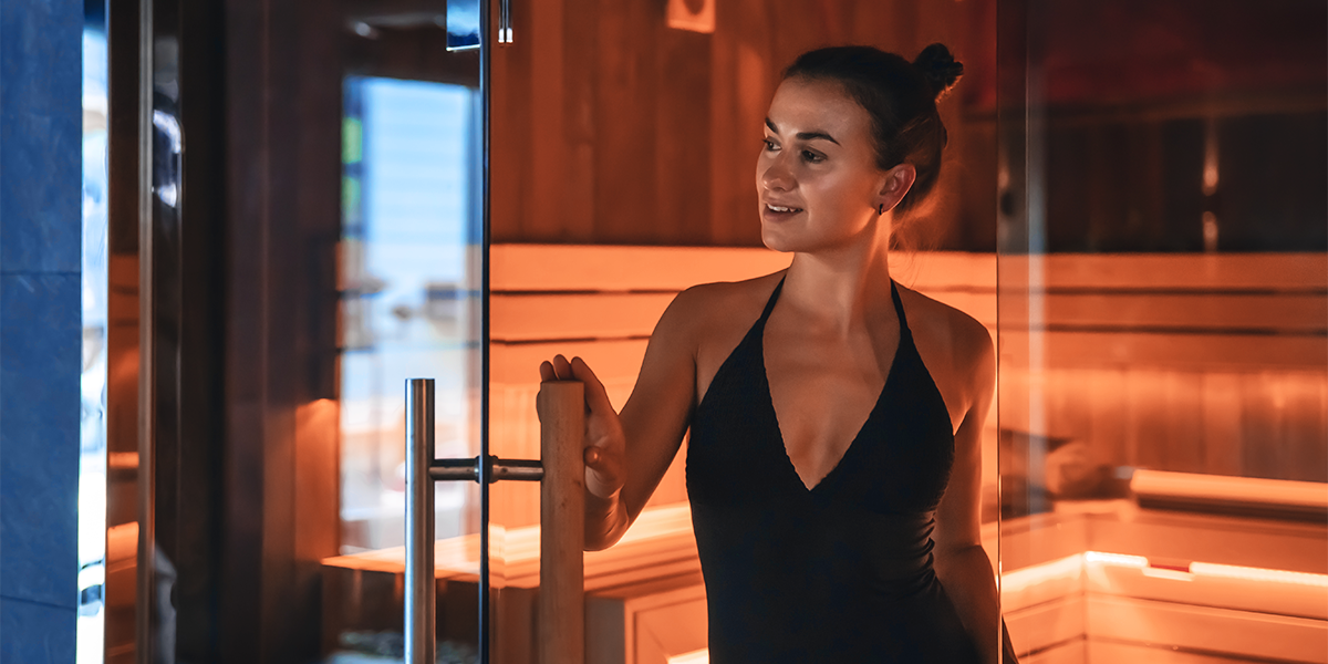 Person in black bathing suit exiting a sauna