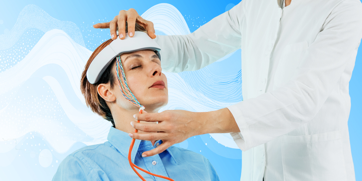 Person sitting with neurofeedback device wired to the head while doctor stands near