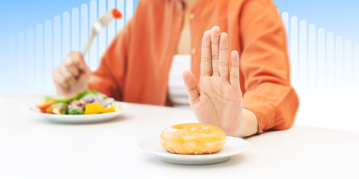 Person enjoying a plate of nutritious foods while rejecting a bun that represents high cholesterol