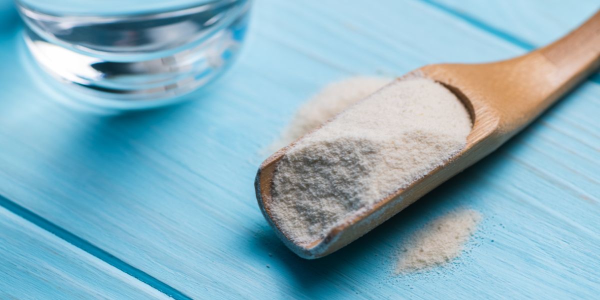 Psyllium husk and glass of water on blue wooden background