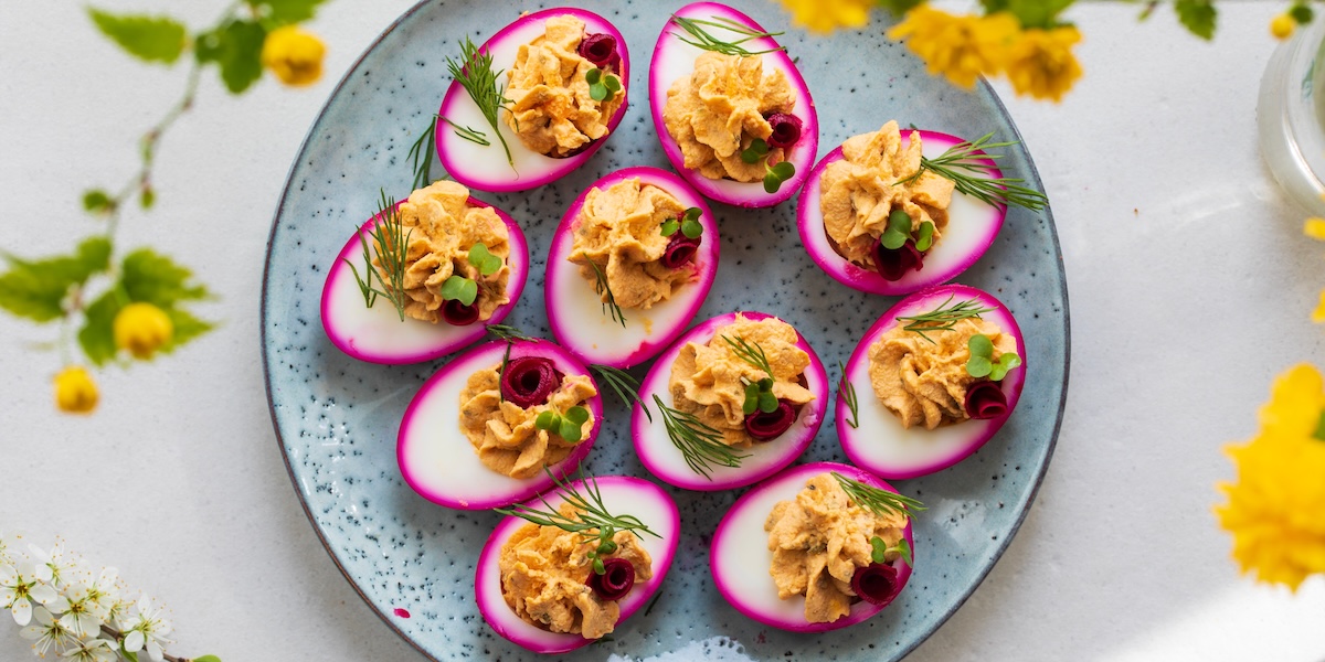 A plate filled with beetroot-pickled deviled eggs