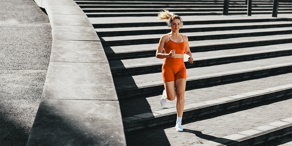 Person in orange sportswear running down the stairs