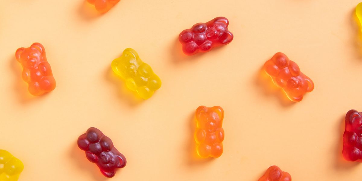 Colored jelly bears on an orange background.