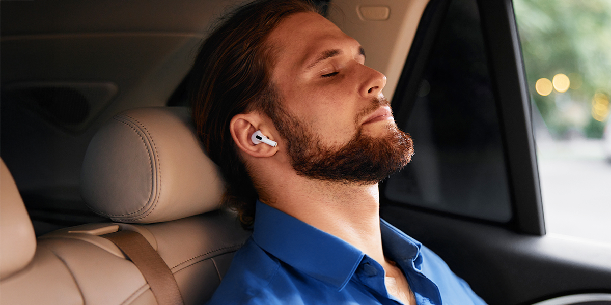 Person sitting in a car resting their vagus nerve with headphones on