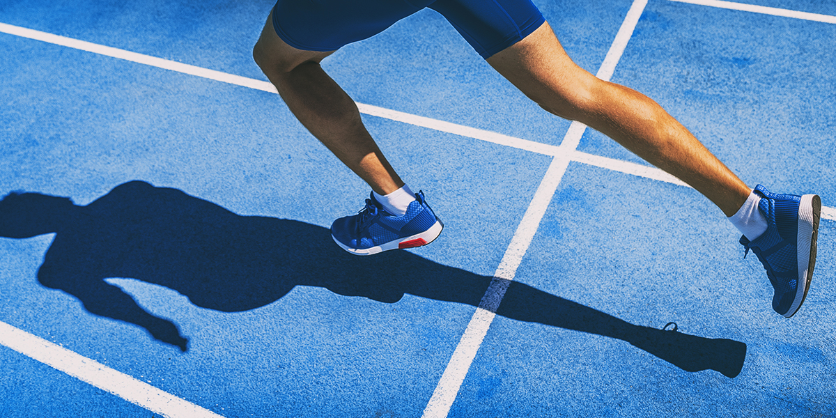 Person running on blue track field