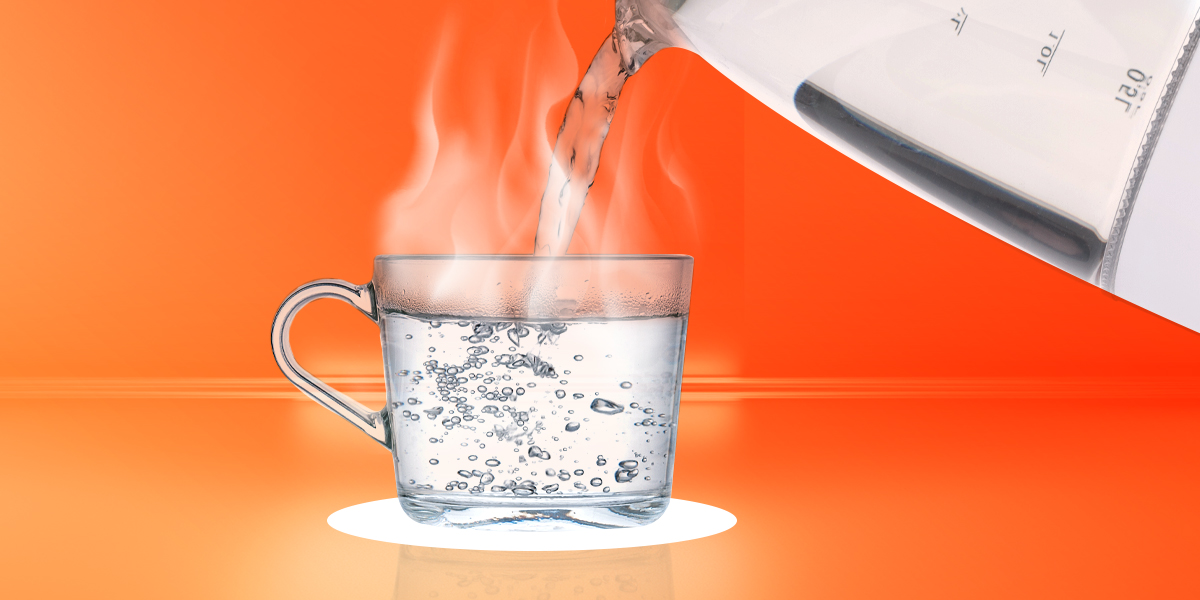 Steaming hot water poured into a glass cup in orange background