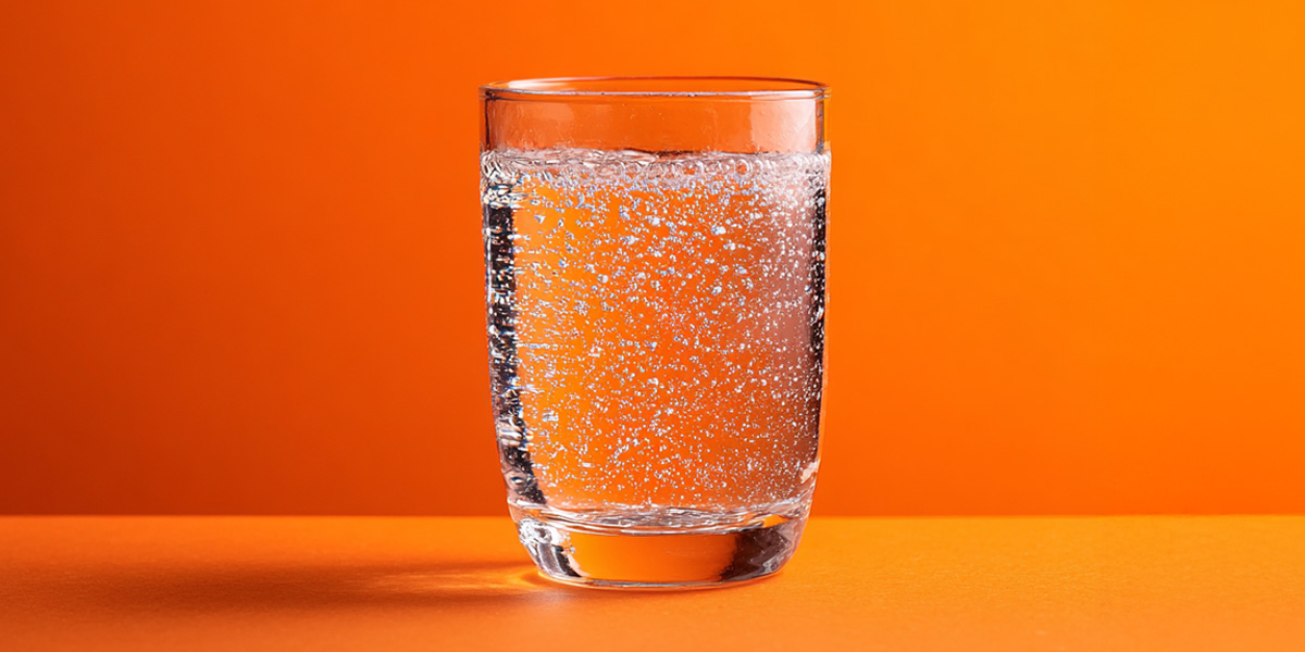 Sparkling Water in a glass orange background