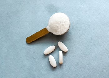 Scoop of marine collagen powder, set against a grey background