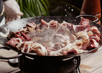 meats frying in a chinese wok pan