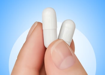 Fingers holding Prebiotics and Probiotics