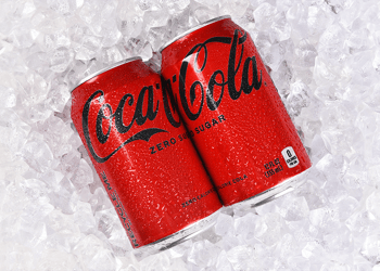 Two Coca Cola cans on ice