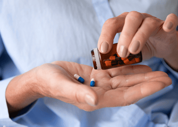 Person pouring L-theanine capsules into their hand