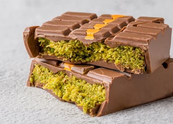 Dubai chocolate bar split in two on a grey background