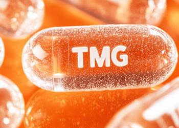 Illustrated close-up of an orange TMG pill set against an orange background