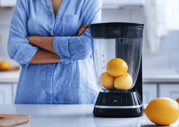 Person blending whole lemons to drink