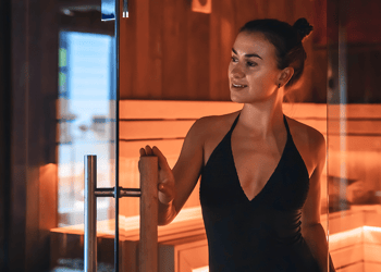 Person in black bathing suit exiting a sauna