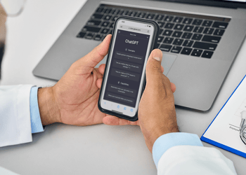 Doctor in white coat using AI on a smart phone