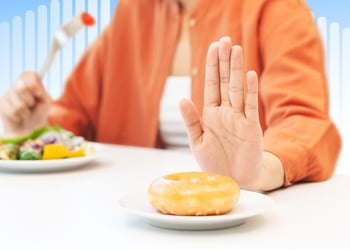 Person enjoying a plate of nutritious foods while rejecting a bun that represents high cholesterol