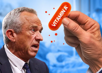 RFK Jr speaking while holding an orange vitamin A capsule on blue medical scene background