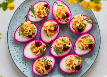 A plate filled with beetroot-pickled deviled eggs