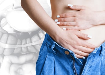 Person feeling their abdomen for ibs symptoms, gut in the background