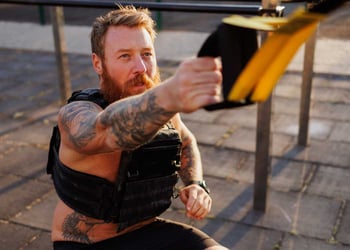 man working out with a weighted vest outside