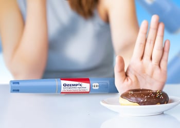 Person saying no to a donut on a plate with ozempic drug in the background