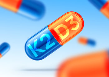 Illustration of a split pill in two: vitamin K2 and D