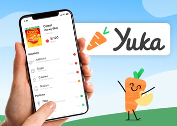 A hand holding a smartphone with the Yuka food scanning app on