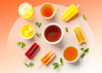 Mint, popsicles, sodas and ice cubes in orange background