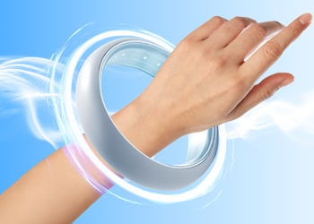 Persons hand wearing a pemf device in blue background