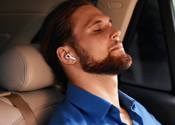 Person sitting in a car resting their vagus nerve with headphones on
