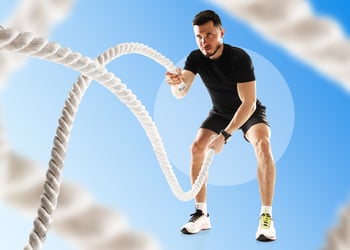 Person training with ropes in blue background