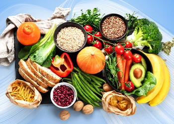 High-fiber foods such as fruits, vegetables, seeds, and whole grains on a black board