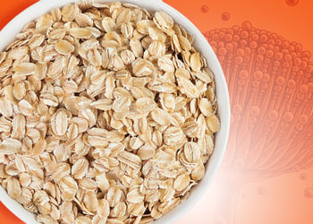 A bowl with raw oats on an orange background