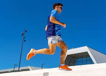 Person running outside sunny day blue background