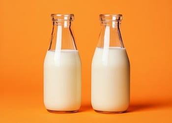 2 bottles of milk in orange background